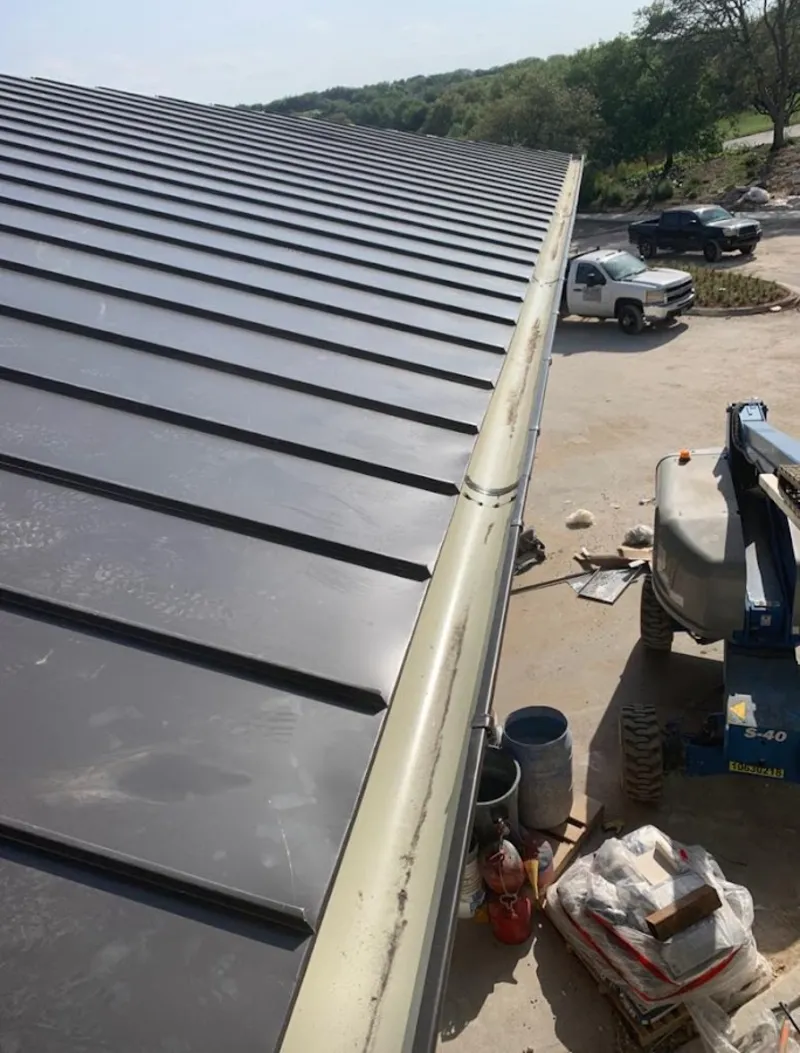 Standing seam panel and gutter detail on a metal roofing jobsite in Talladega